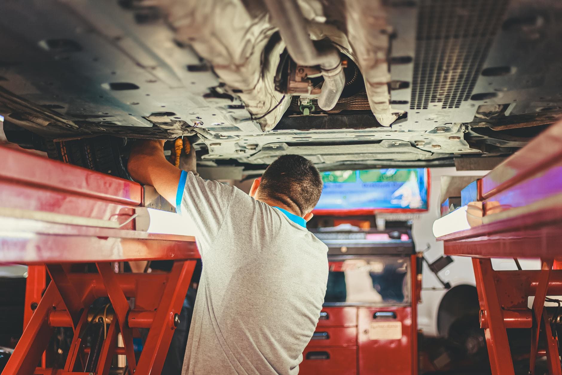 Mechanic working under a car in a shop